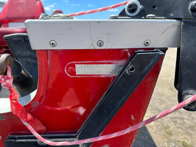 Slide: The Image of Close-up of a red 1995 Lund 1660 Pro V Tiller boat part with visible serial number. - 17