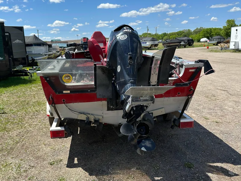 Slide: The Image of 1995 Lund 1660 Pro V Tiller boat with outboard motor on a trailer, parked outdoors. - 5