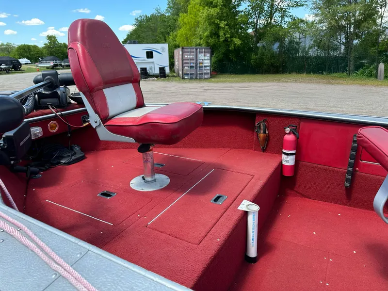 Slide: The Image of Red interior of 1995 Lund 1660 Pro V Tiller boat with swivel seat and fire extinguisher. - 8