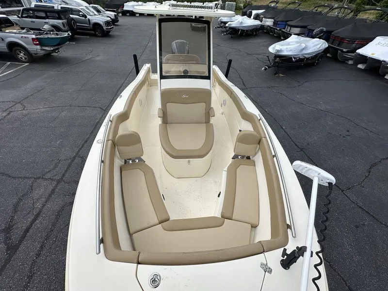 Slide: The Image of 2019 Scout 235 XSF boat with beige seating, parked in a lot with other boats. - 14