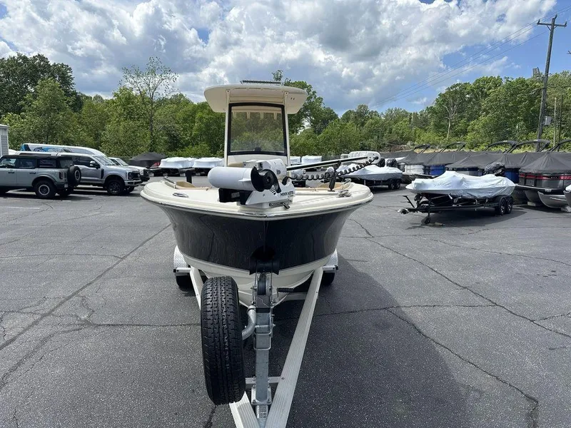 Slide: The Image of 2019 Scout 235 XSF boat on trailer in parking lot, surrounded by trees and vehicles. - 3