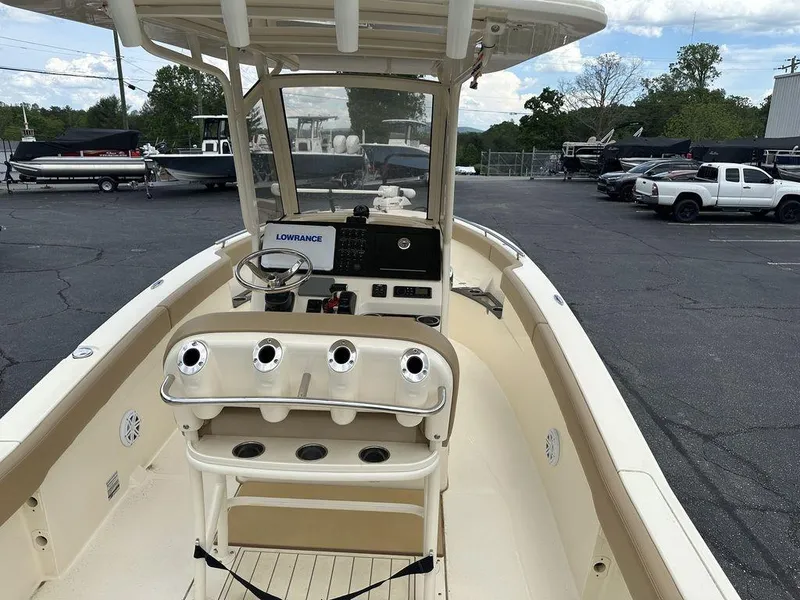 Slide: The Image of 2019 Scout 235 XSF boat with helm, Lowrance system, and rod holders in a parking lot. - 8