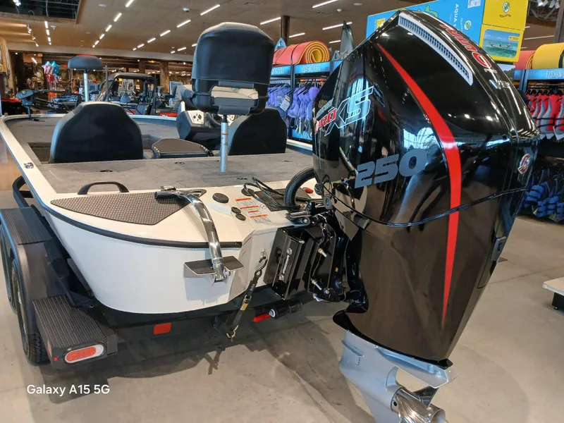 Slide: The Image of 2025 Tracker Savage 215 boat with powerful 250 HP engine displayed indoors. - 2