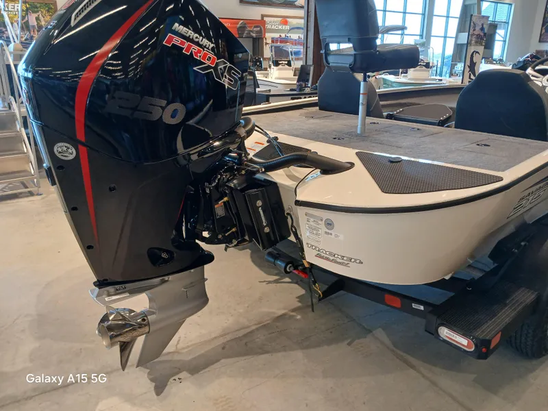 Slide: The Image of 2025 Tracker Savage 215 boat with powerful outboard motor in showroom setting. - 3