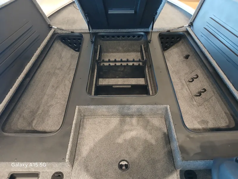 Slide: The Image of Interior of 2025 Tracker Savage 215 boat with storage compartments and carpeted flooring. - 4