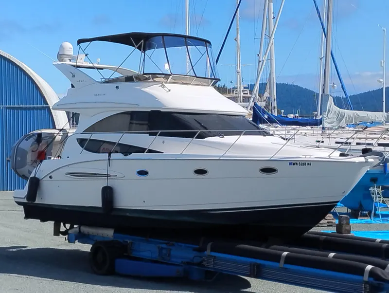 Slide: The Image of 2006 Meridian 341 Sedan yacht on trailer at marina, blue sky background. - 1