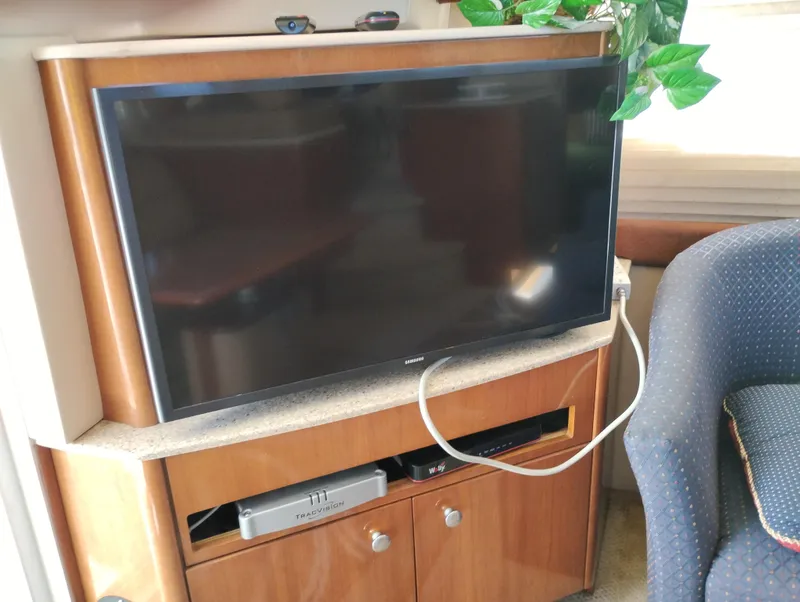 Slide: The Image of Flat-screen TV setup in 2006 Meridian 341 Sedan interior with wooden cabinetry. - 25