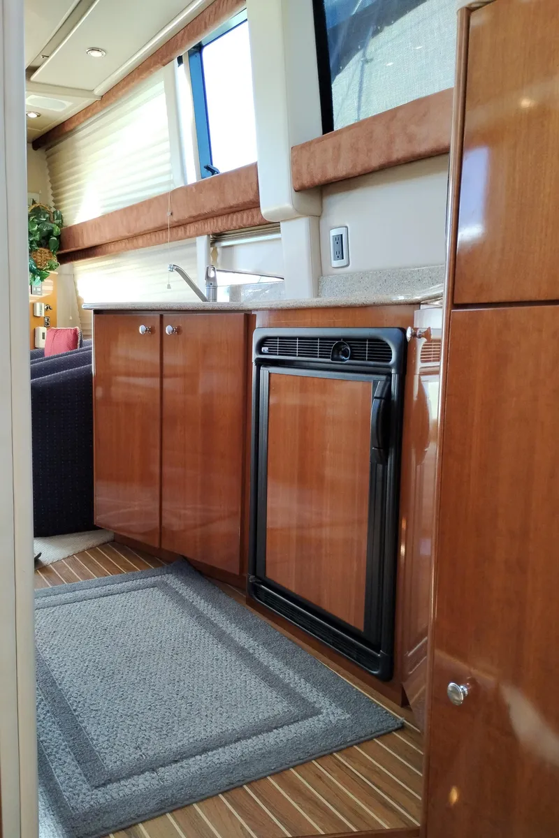 Slide: The Image of 2006 Meridian 341 Sedan yacht interior with wood cabinetry and compact kitchen area. - 32