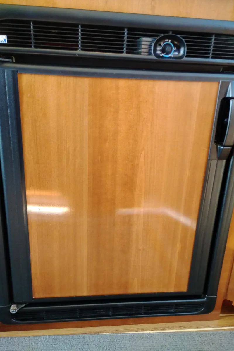 Slide: The Image of Wood-paneled refrigerator in 2006 Meridian 341 Sedan yacht interior. - 33
