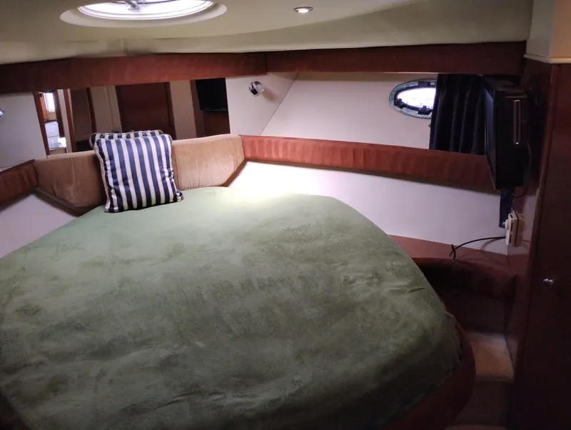 Slide: The Image of 2006 Meridian 341 Sedan cabin with a cozy bed, green cover, and striped pillow. - 47