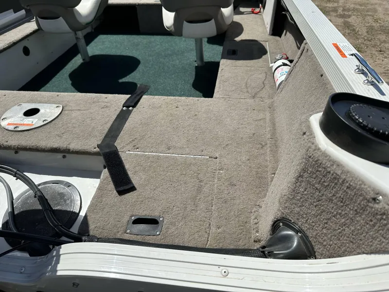 Slide: The Image of 2004 Crestliner 1750 Fish Hawk SC interior with carpeted deck and seating. - 16