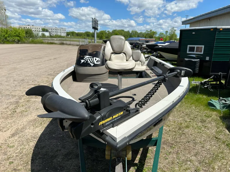 Slide: The Image of 2004 Crestliner 1750 Fish Hawk SC boat with trolling motor, parked outdoors under a blue sky. - 4