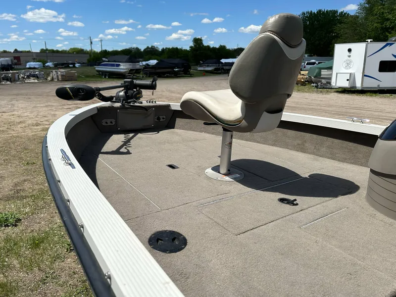 Slide: The Image of 2004 Crestliner 1750 Fish Hawk SC boat with fishing seat and trolling motor, parked outdoors. - 6