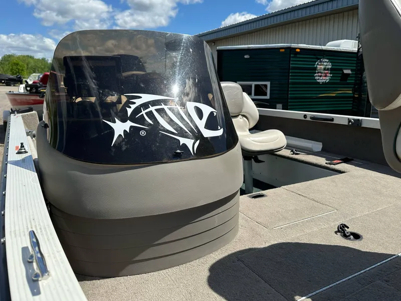 Slide: The Image of 2004 Crestliner 1750 Fish Hawk SC boat interior with fish decal, beige seating, and clear windshield. - 9