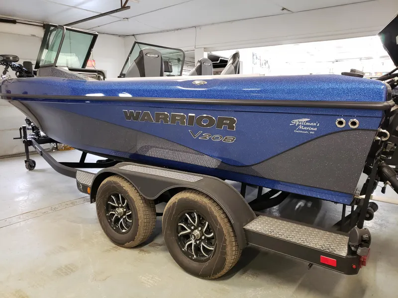 Slide: The Image of 2025 Warrior 208 boat on trailer in garage, blue exterior, dual-axle wheels. - 3