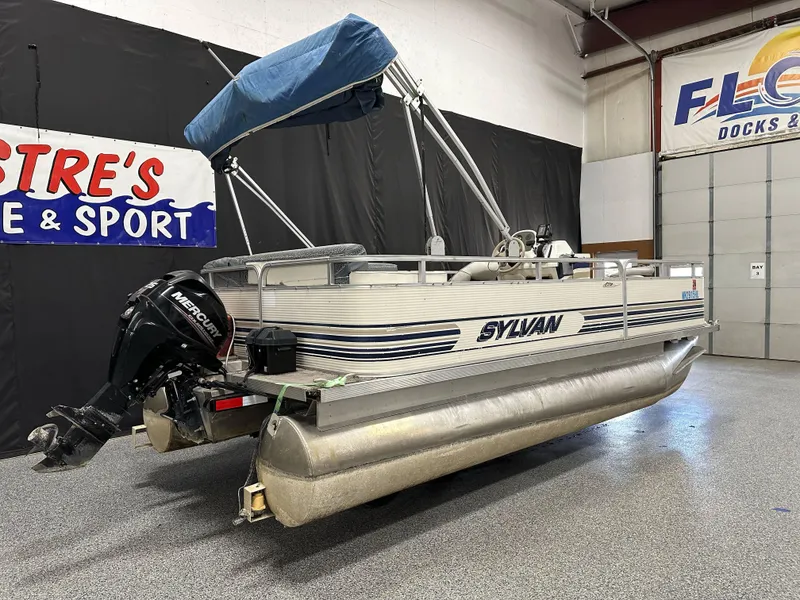 Slide: The Image of 1998 Sylvan Elite 20 pontoon boat with Mercury outboard motor in showroom. - 1