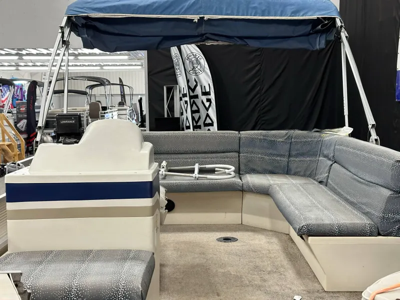 Slide: The Image of 1998 Sylvan Elite 20 pontoon boat interior with blue canopy and gray seating. - 10