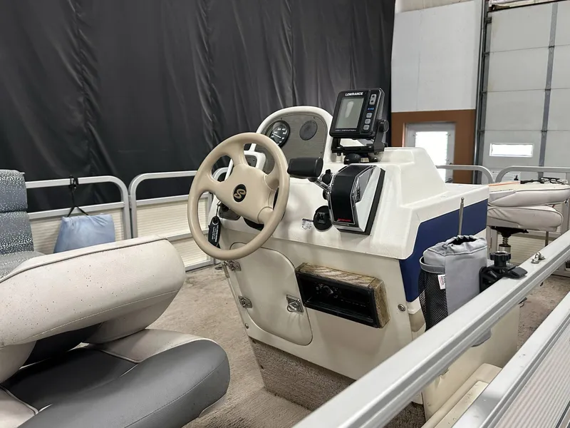 Slide: The Image of 1998 Sylvan Elite 20 boat interior with steering wheel and navigation equipment. - 13