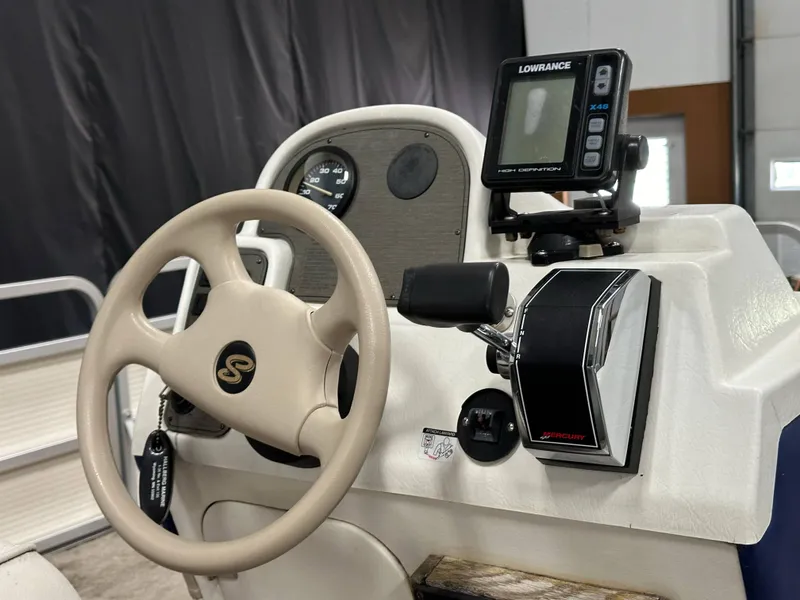 Slide: The Image of 1998 Sylvan Elite 20 boat dashboard with steering wheel and Lowrance fish finder. - 14
