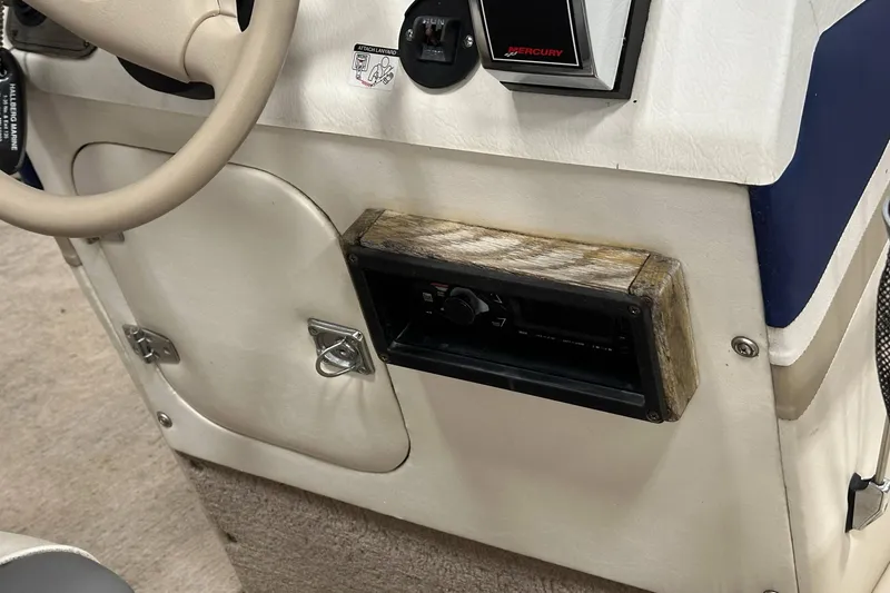 Slide: The Image of 1998 Sylvan Elite 20 boat dashboard with steering wheel and control panel. - 15