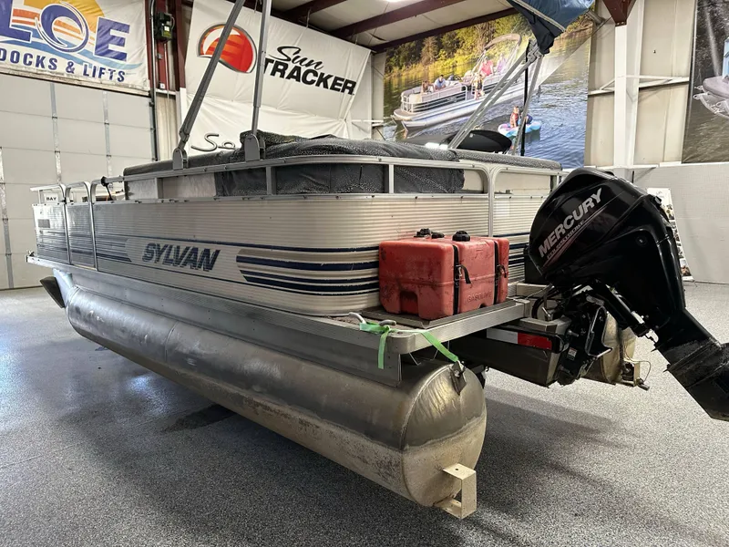 Slide: The Image of 1998 Sylvan Elite 20 pontoon boat with Mercury outboard motor in a showroom. - 4