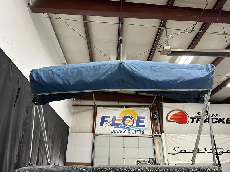 Slide: The Image of Blue canopy on a 1998 Sylvan Elite 20 boat in a warehouse setting. - 6
