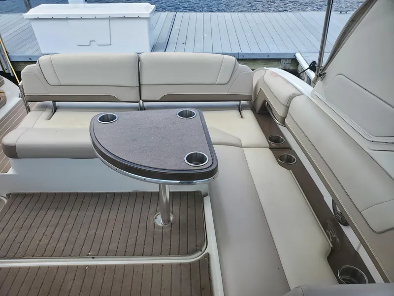 Slide: The Image of 2015 Formula 330 Crossover Bowrider interior with cushioned seating and table. - 10