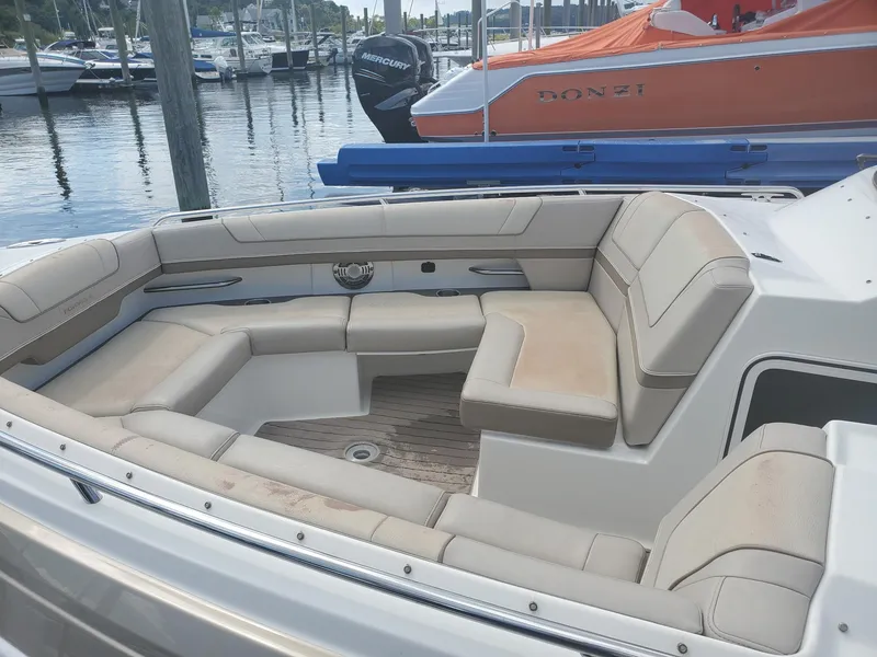 Slide: The Image of 2015 Formula 330 Crossover Bowrider with spacious seating at a marina. - 11