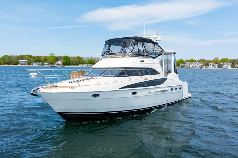 Slide: The Image of 2004 Meridian 459 Motor Yacht cruising on a serene lake under a clear blue sky. - 10