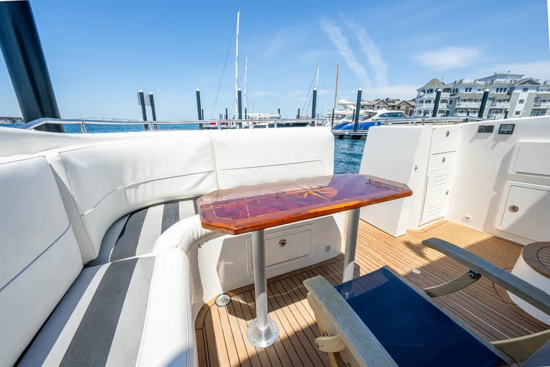 Slide: The Image of Luxurious 2004 Meridian 459 Motor Yacht deck with seating and table, docked at marina. - 12