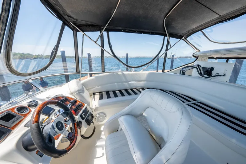 Slide: The Image of Luxurious 2004 Meridian 459 Motor Yacht interior with white seating and steering wheel, overlooking water. - 21