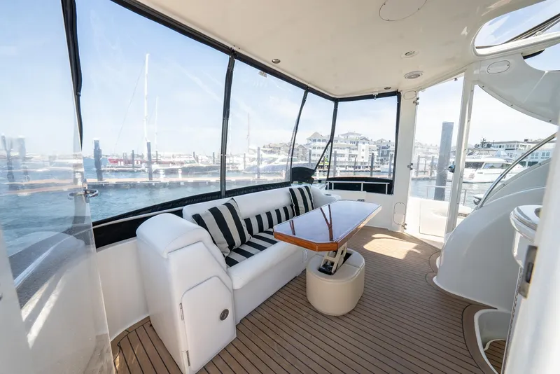 Slide: The Image of Luxurious 2004 Meridian 459 Motor Yacht interior with seating and table, overlooking marina. - 23