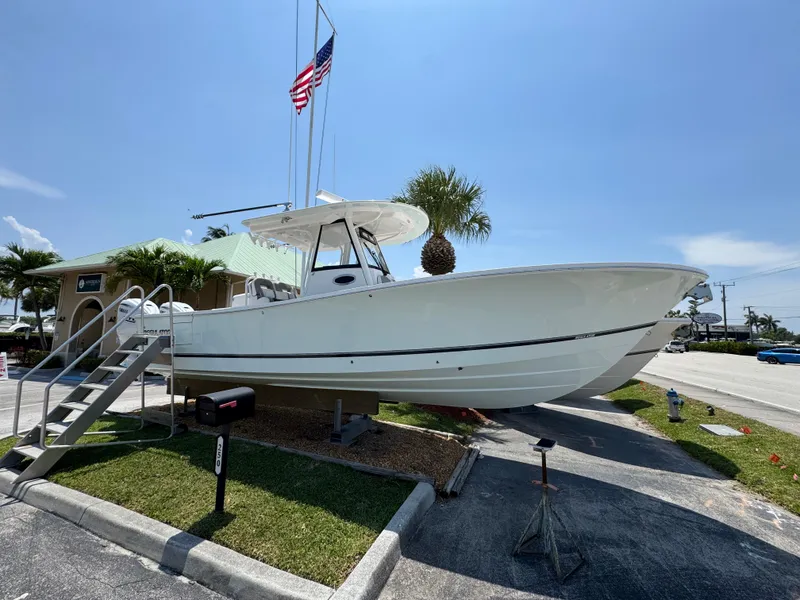 Slide: The Image of 2024 Regulator 31 boat displayed outdoors with American flag and palm trees. - 1