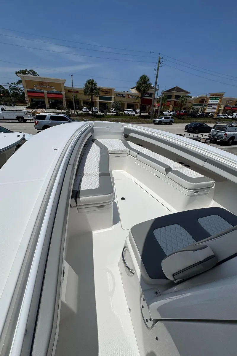 Slide: The Image of 2024 Regulator 31 boat with spacious seating and sleek design, docked near shops. - 11