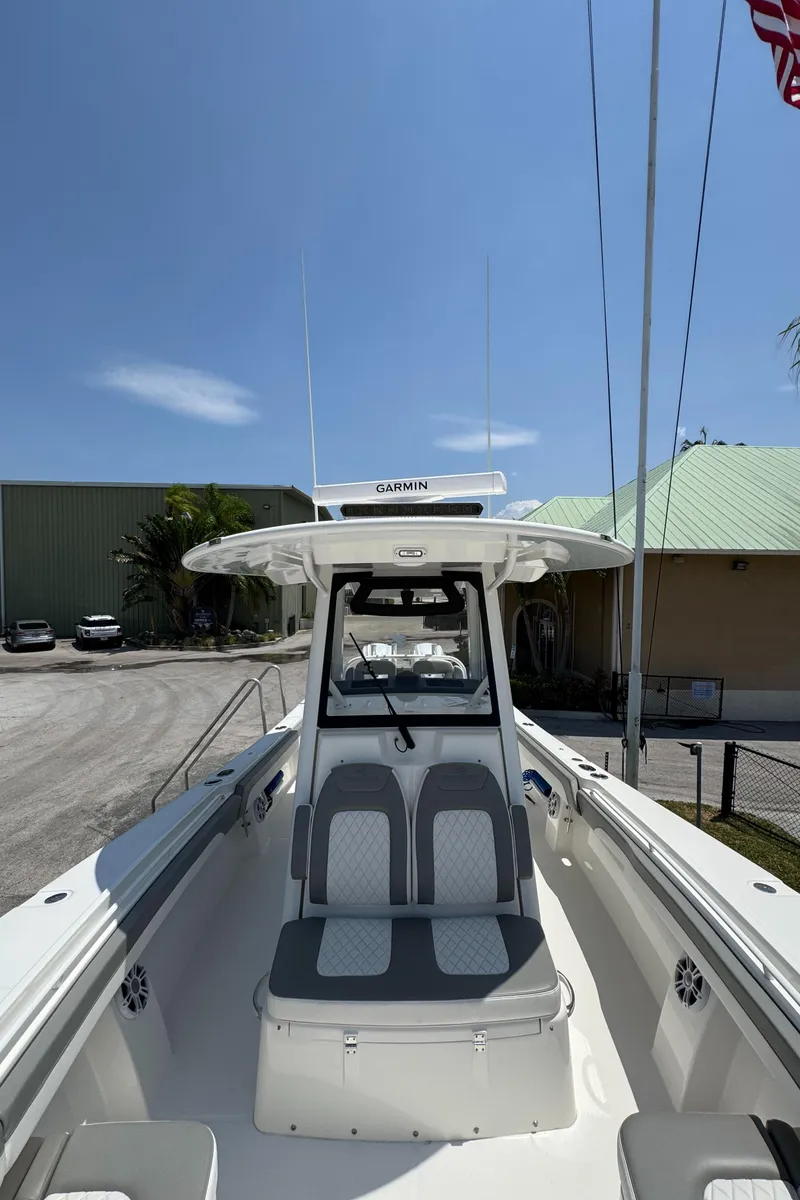 Slide: The Image of 2024 Regulator 31 boat with dual seats and Garmin equipment under a clear blue sky. - 13