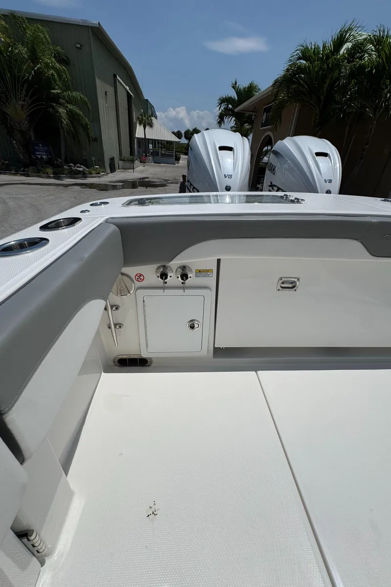 Slide: The Image of 2024 Regulator 31 boat deck with dual engines, docked near palm trees. - 15