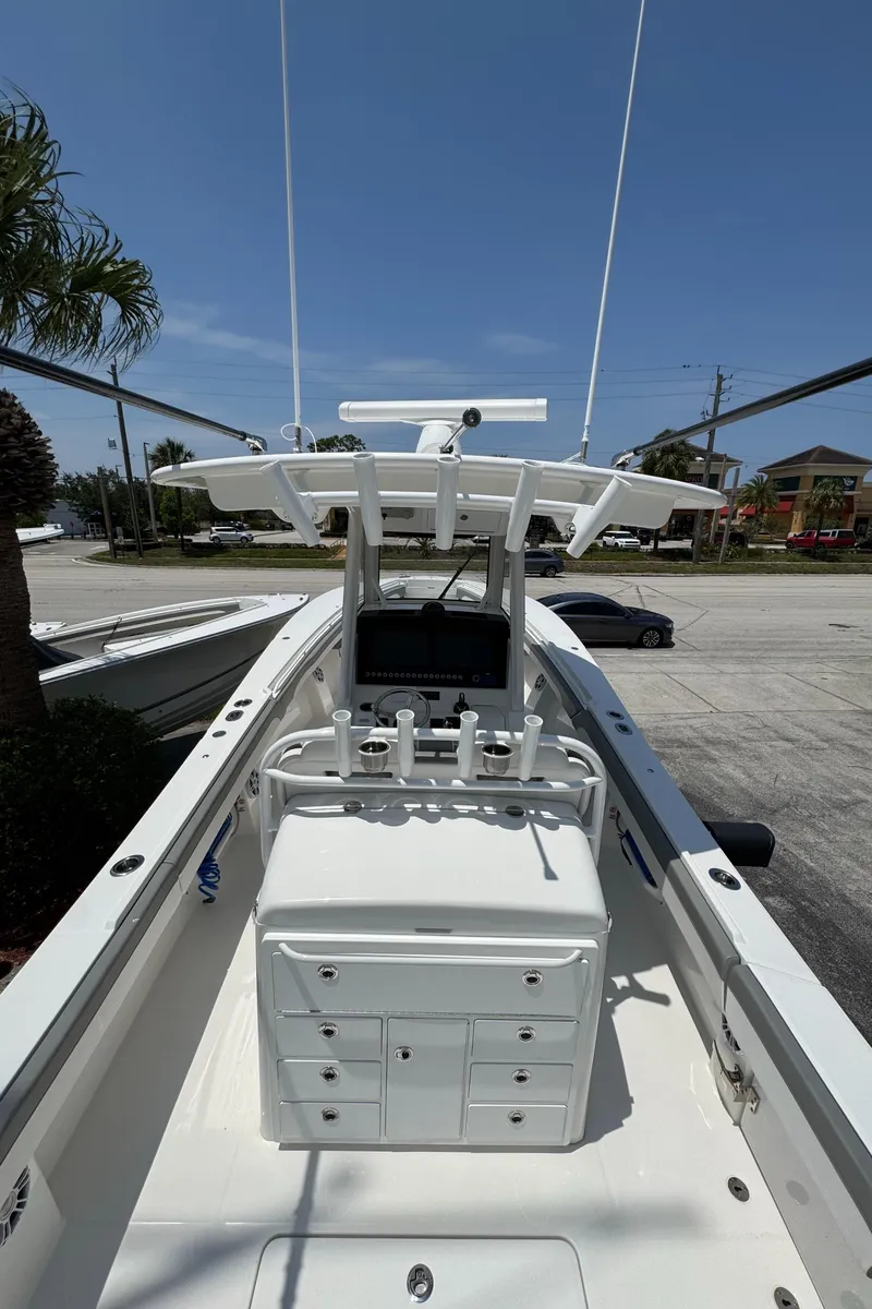 Slide: The Image of 2024 Regulator 31 boat, center console, clear sky, palm trees, street view. - 3
