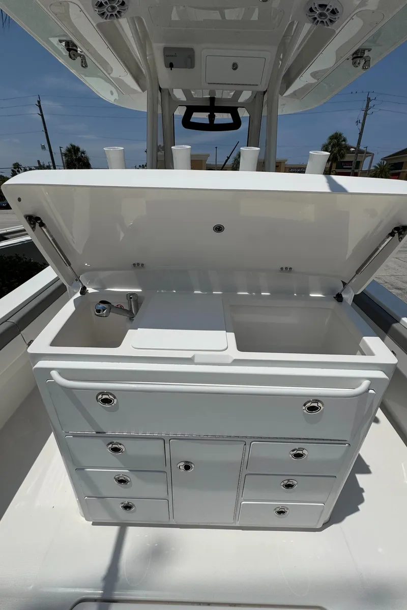 Slide: The Image of 2024 Regulator 31 boat interior with open storage compartments and sink. - 5
