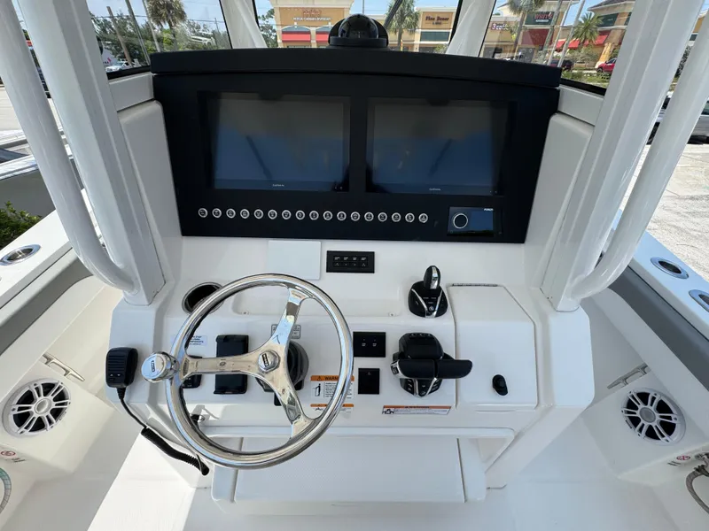 Slide: The Image of 2024 Regulator 31 boat dashboard with dual screens and steering wheel. - 8
