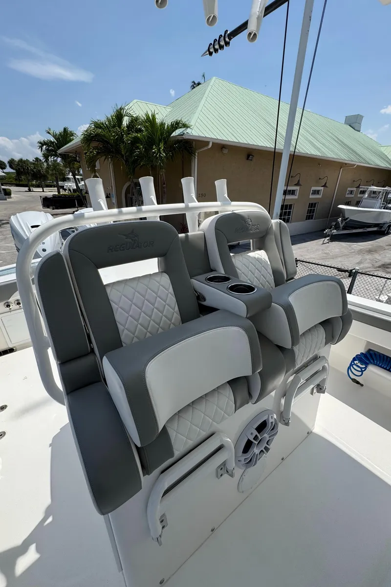 Slide: The Image of 2024 Regulator 31 boat seats with cup holders, docked near a building with a green roof. - 9