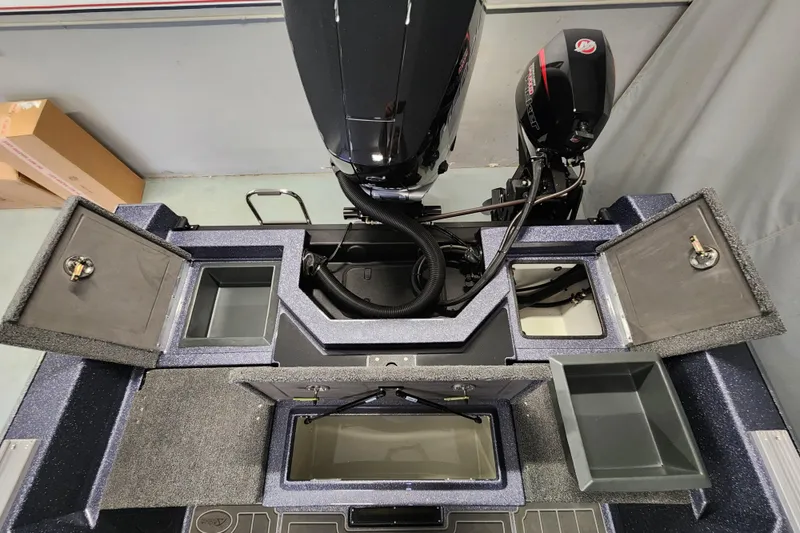Slide: The Image of 2025 Warrior V238 boat interior with open storage compartments and motor. - 14