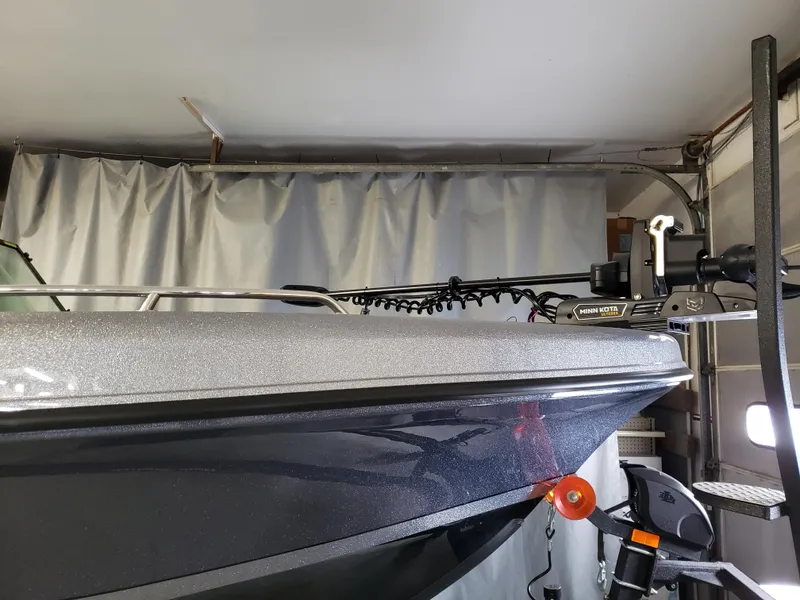 Slide: The Image of 2024 Warrior V238 boat in garage, featuring a Minn Kota trolling motor. - 17