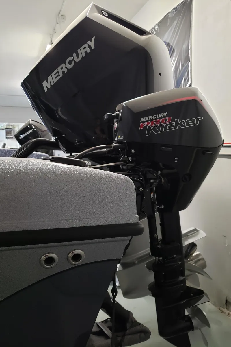 Slide: The Image of 2024 Warrior V238 boat with Mercury Pro Kicker outboard motor in a showroom. - 18