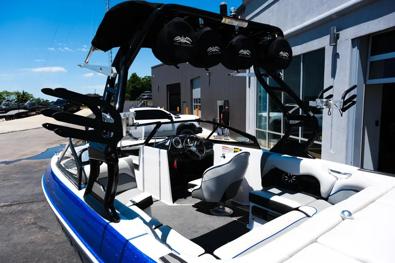 Slide: The Image of 2017 Moomba Mondo boat with blue and white interior, parked near a building. - 11