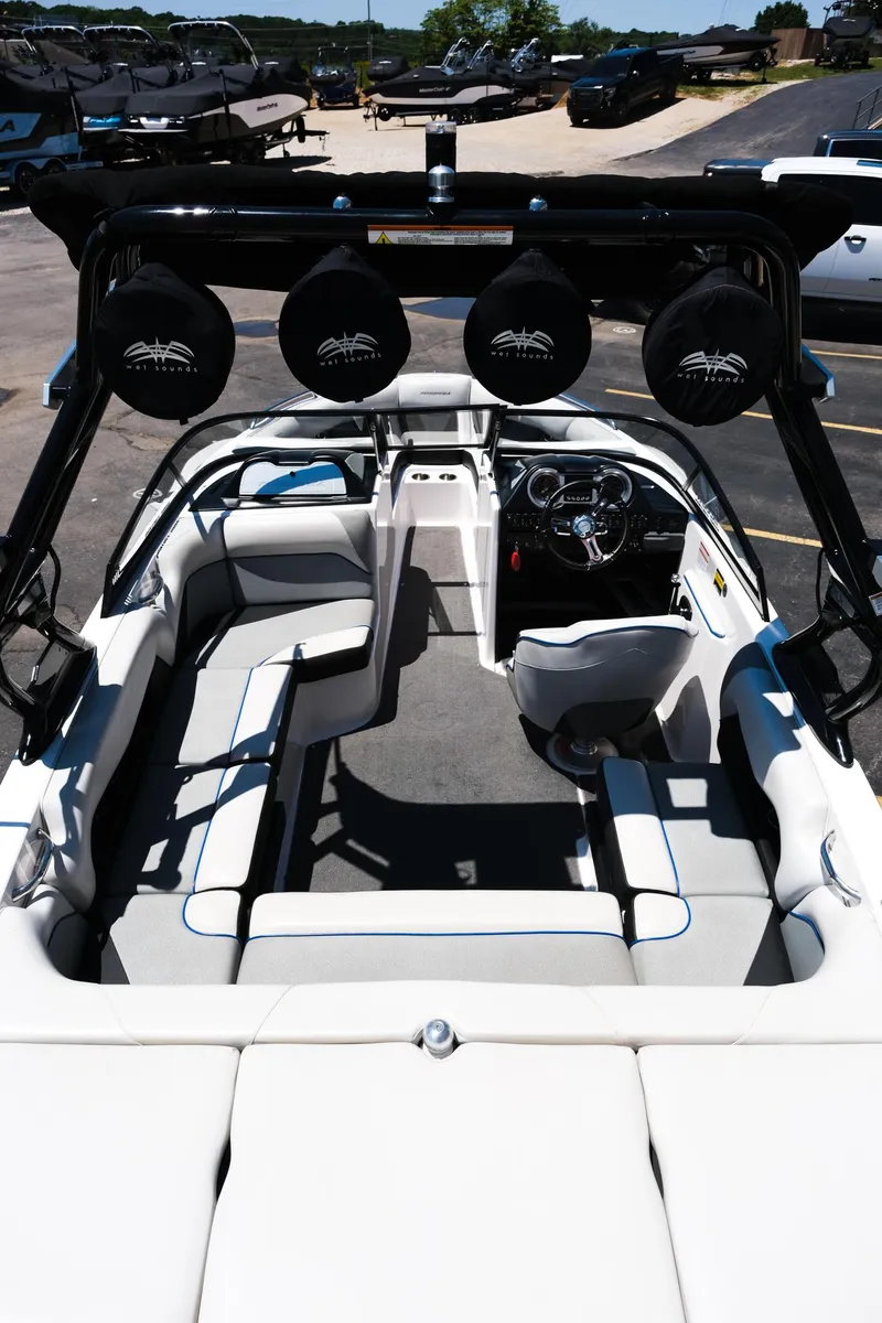 Slide: The Image of 2017 Moomba Mondo boat interior with seating and steering wheel, docked outdoors. - 12