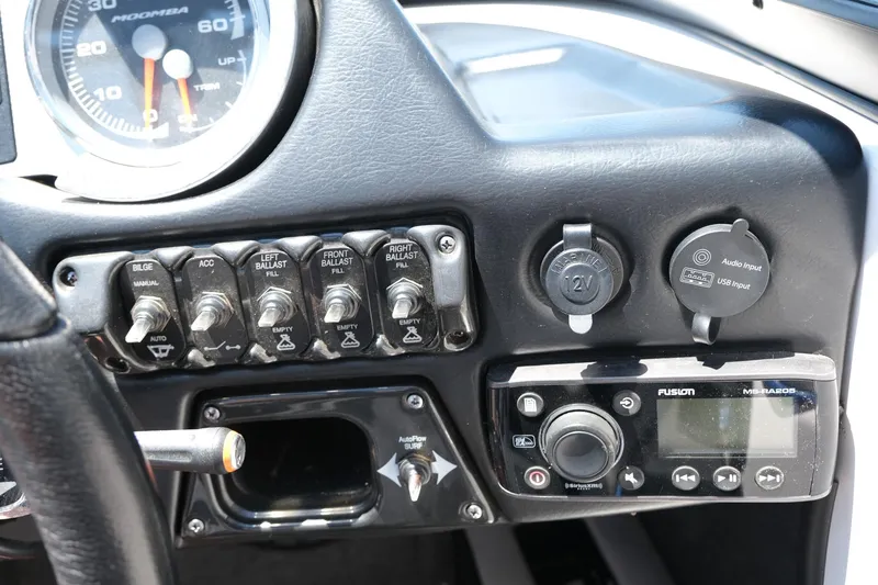 Slide: The Image of Dashboard controls of a 2017 Moomba Mondo boat with switches and a Fusion stereo system. - 25