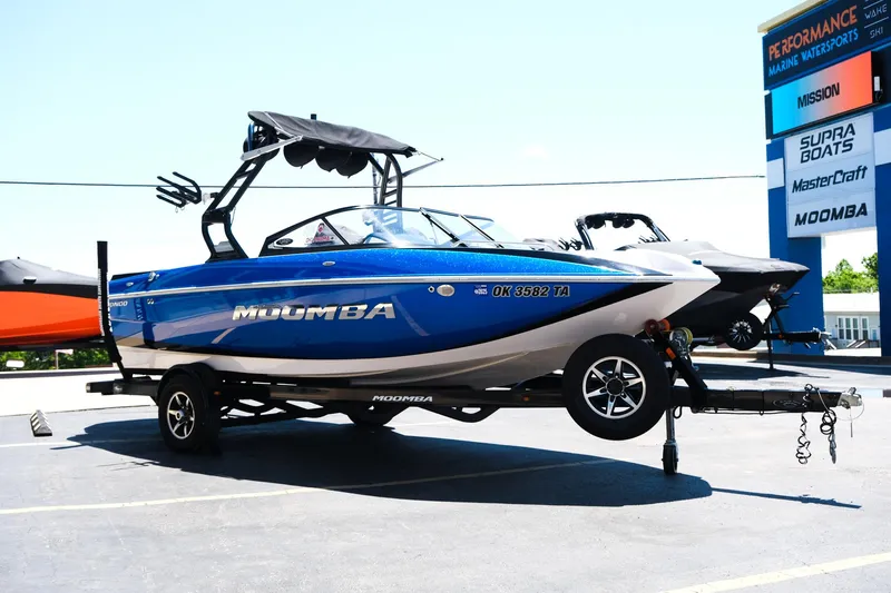 Slide: The Image of 2017 Moomba Mondo boat on trailer at dealership, blue and white design. - 7
