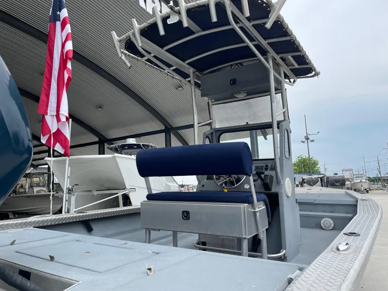 Slide: The Image of 2009 Hanko 247 boat with American flag, featuring a center console and blue seating. - 4