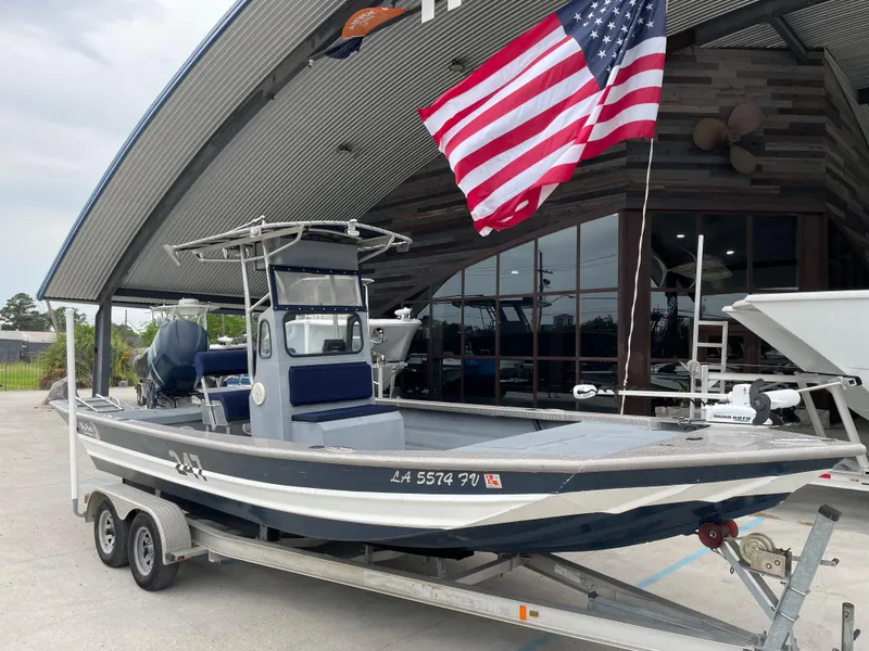 Slide: The Image of 2009 Hanko 247 boat on trailer, American flag, parked outside a modern building. - 6
