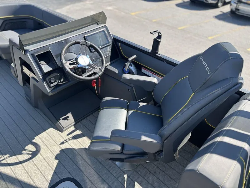 Slide: The Image of 2023 Manitou Explore 22 Max Bench boat interior with steering wheel and captain's chair. - 11